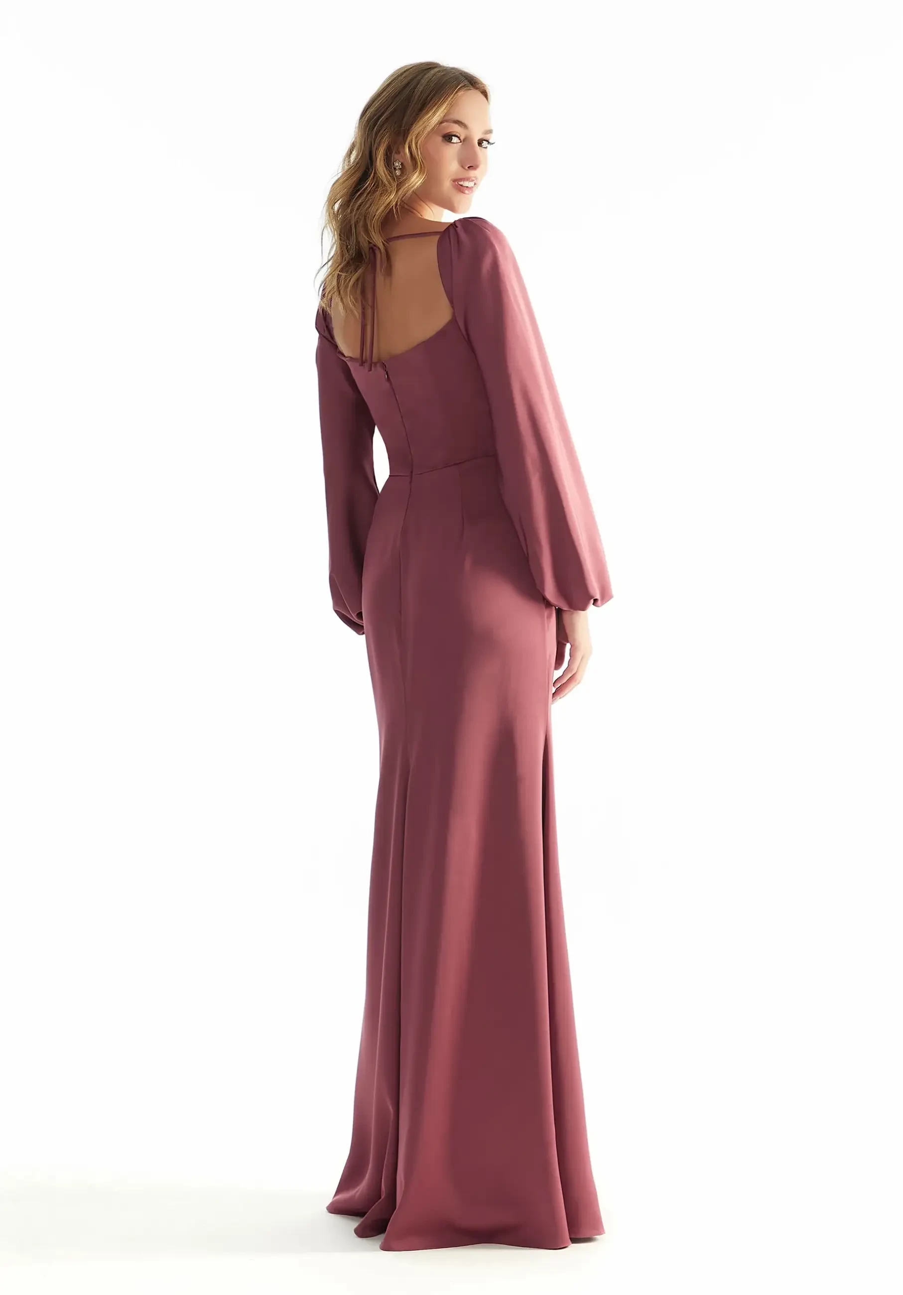 Model is wearing a satin A-line bridesmaid dress with a corset bodice, cowl neckline, bishop sleeves, and a strappy open back.
