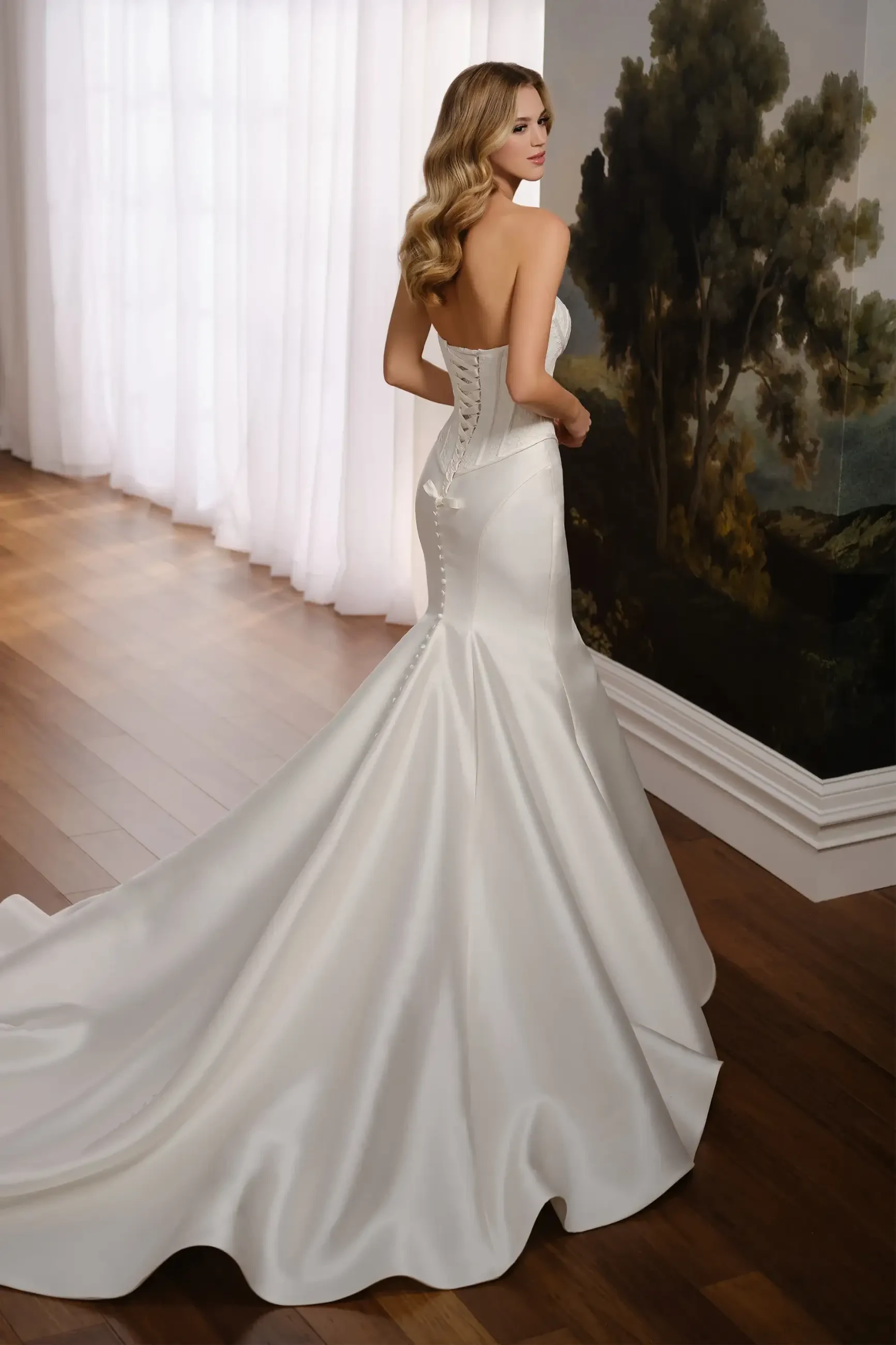 Model is wearing a trumpet-style gown with a lace bodice, Mikado skirt, and a modesty panel at the back